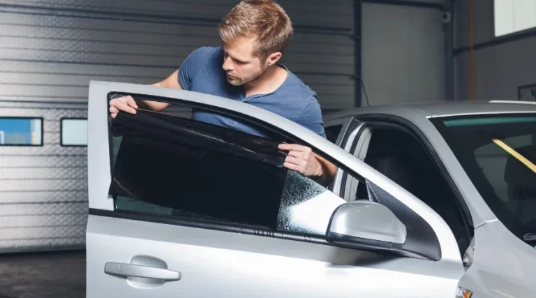 man putting tint on a car window